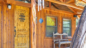 Una cabaña de madera con una puerta grande, un banco afuera y un letrero que dice "Creekside".
