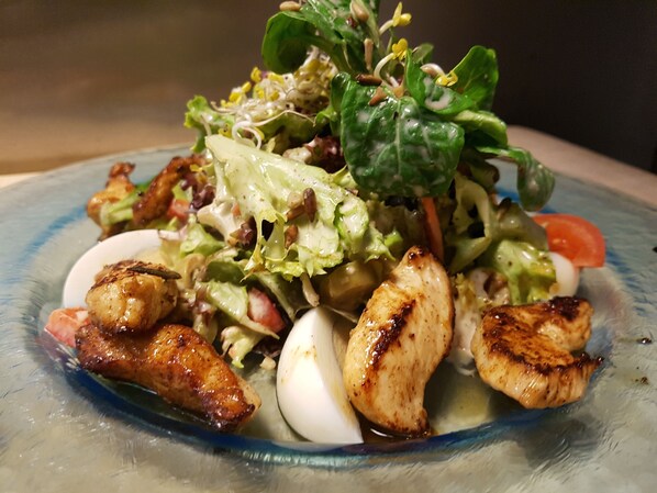 A plate of food with grilled chicken, eggs, and a salad. - Hotel Restaurant Dragonerbau (Langenselbold)