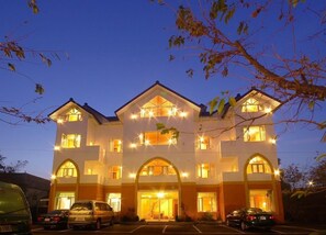 A multi-story hotel with a symmetrical facade, large arched windows, and multiple balconies. - Sea of Clouds Vacation Villa (Ren'ai)