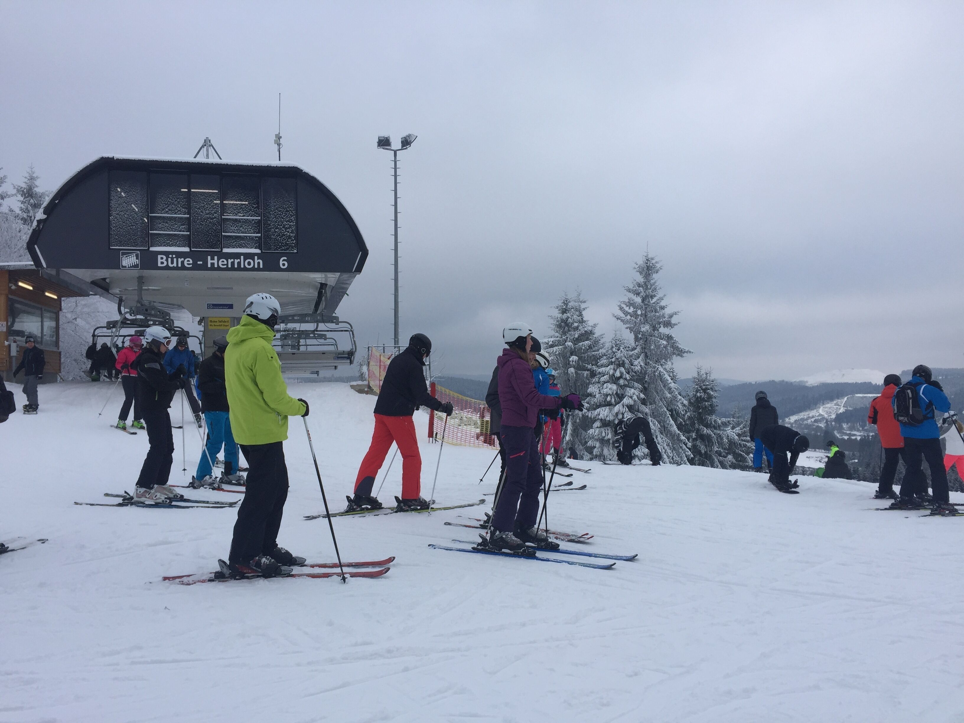 Une piste de ski où des skieurs se préparent à dévaler la pente.
