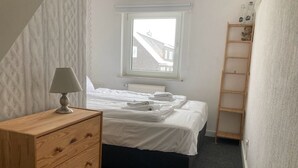 A bedroom with a bed, a wooden dresser, a window, and a ladder. - TOP - APPARTMENT - WINTERBERG**** (max. 6 people) Prime location **** (Winterberg)