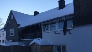 A house with a sloped roof covered in snow, a satellite dish, and a wooden fence. - TOP - APPARTMENT - WINTERBERG**** (max. 6 people) Prime location **** (Winterberg)