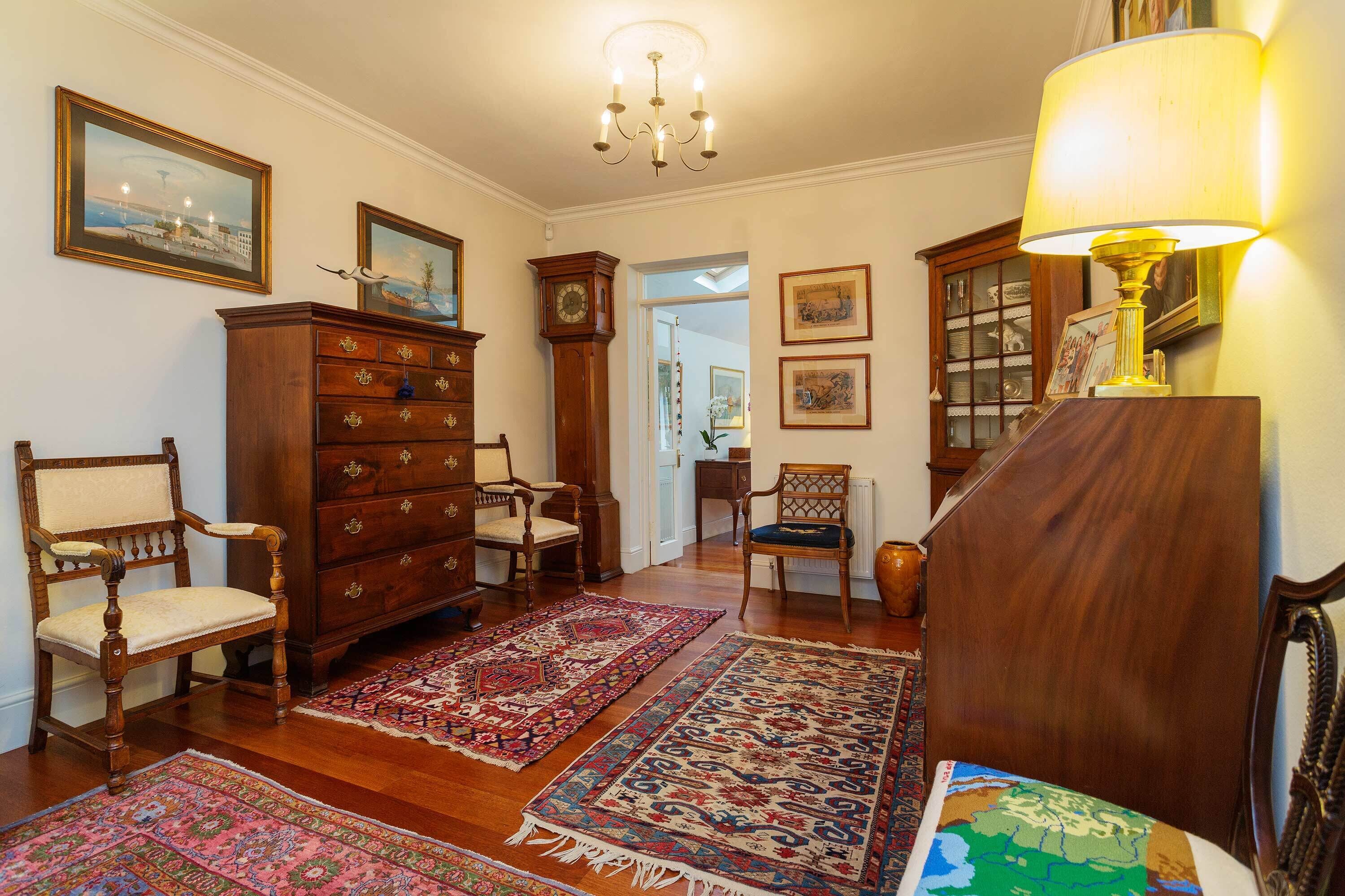 A traditional room with wooden furniture, a chandelier, and patterned rugs.