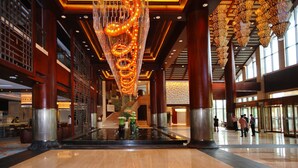 A spacious lobby with a central water feature, large wooden columns, and a modern chandelier. - Yangming Springs and Spa Resort (Ningbo)