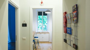 A hallway with a window, a door, and a wall-mounted book rack. - The Andy House B&B (Naples)