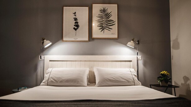A neatly made bed with white linens and two pillows, flanked by two bedside lamps. - The Andy House B&B (Naples)