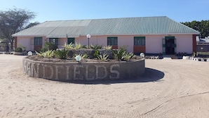 Ein Gebäude mit Gründach und einem Schild, auf dem im Vordergrund „SANDFIELDS“ steht.