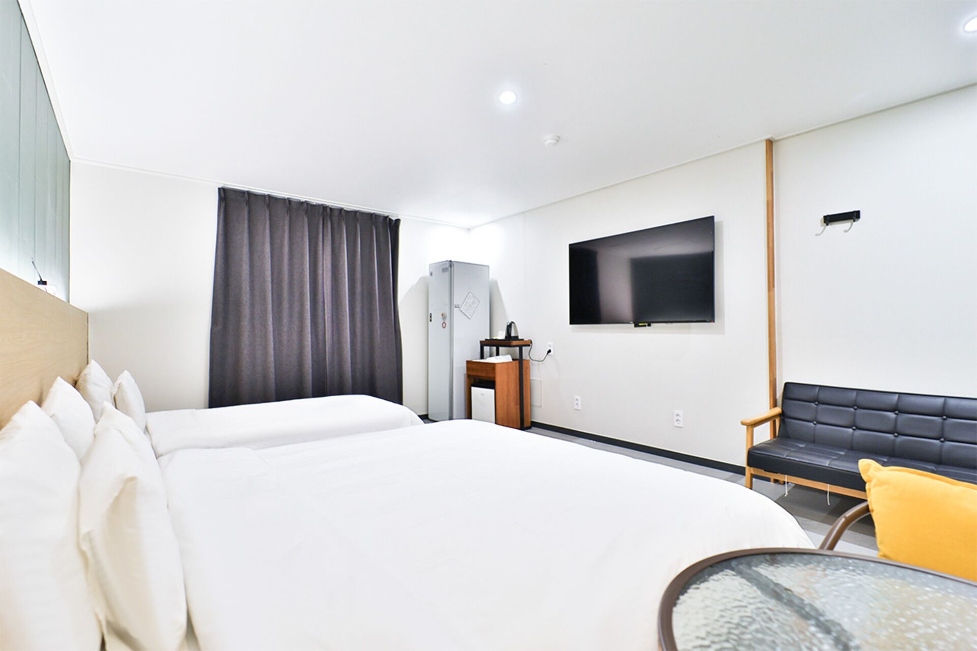 Une chambre d’hôtel moderne dotée d’un grand lit, d’une télévision à écran plat, d’un bureau avec une chaise et d’un canapé.