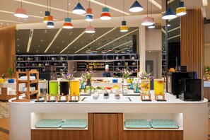 A breakfast station with a variety of food items and a coffee machine.