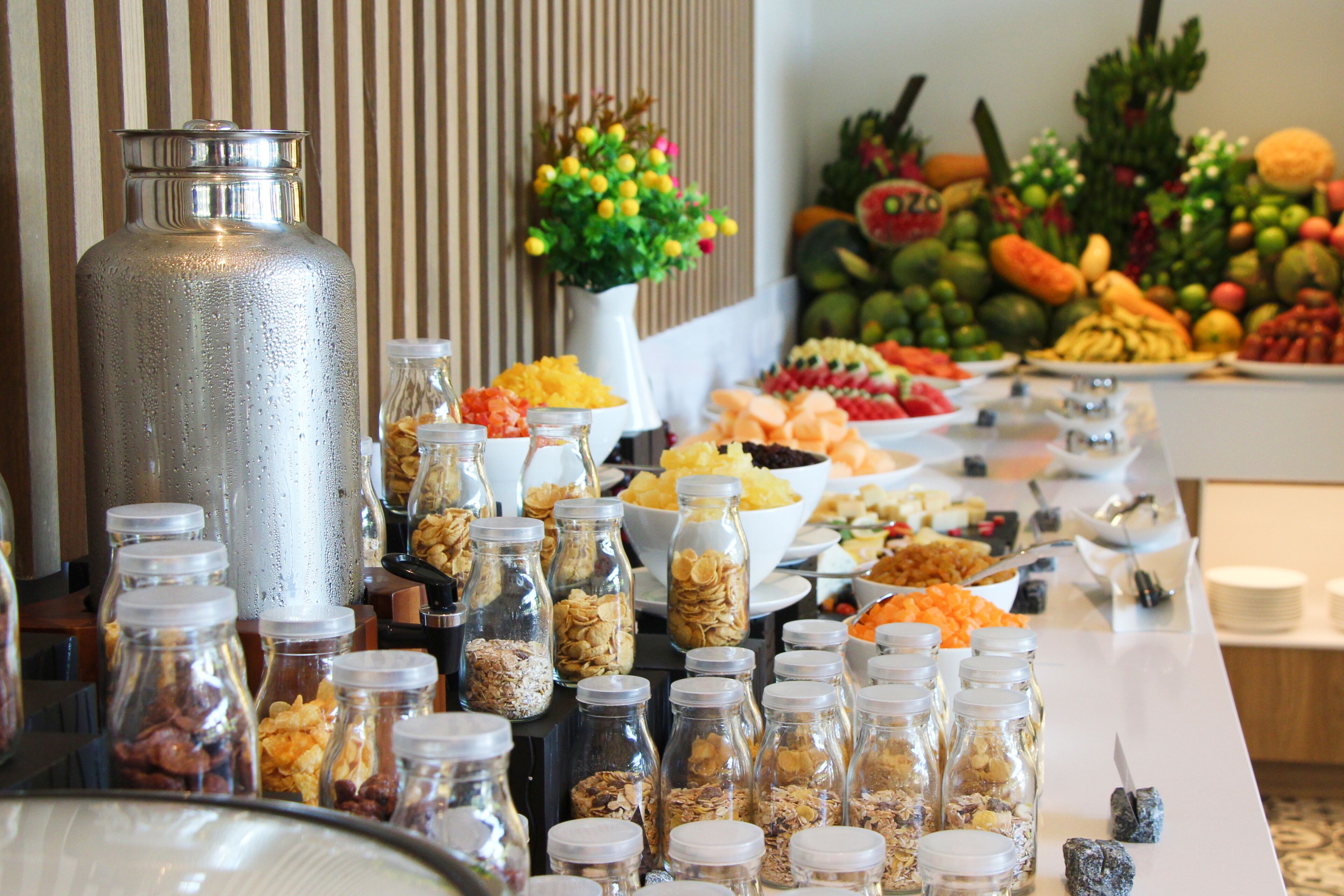 A buffet table with various food items and condiments.
