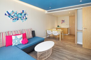 Un espacio de estar moderno con un sofá, una mesita redonda y una mesa de comedor con sillas.
