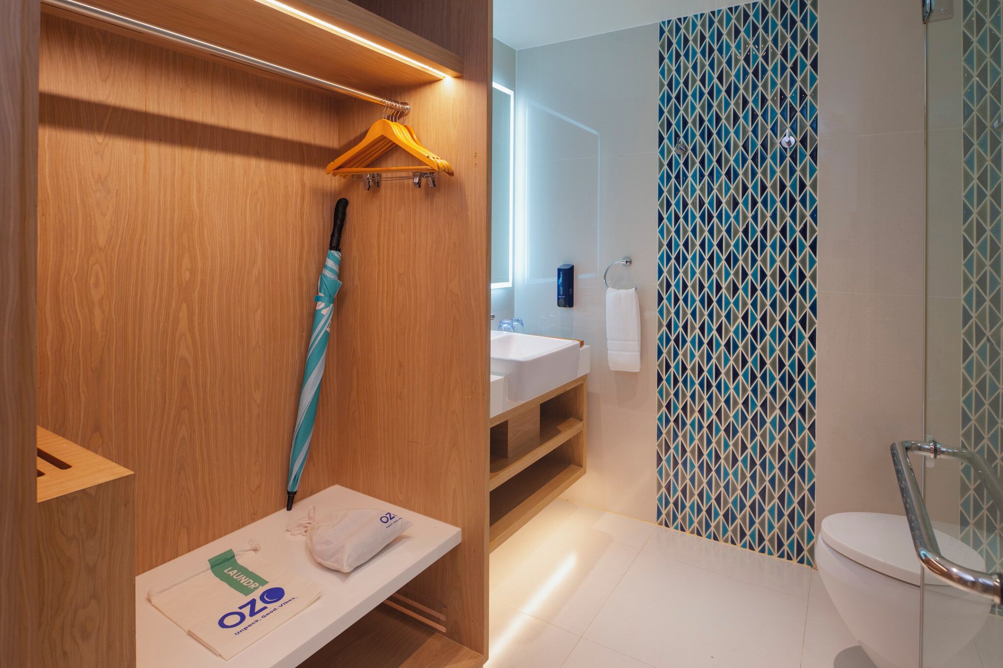 A modern bathroom with a wooden vanity, a sink, and a shower area.