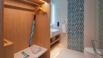 A modern bathroom with a wooden vanity, a sink, and a shower area.