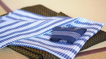 A neatly folded set of checkered tablecloths in various patterns and colors, including blue, brown, and black, arranged on a wooden surface.