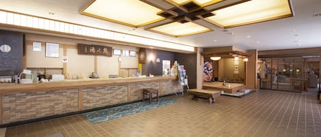 A reception area with a wooden counter, seating, and a decorative wall.