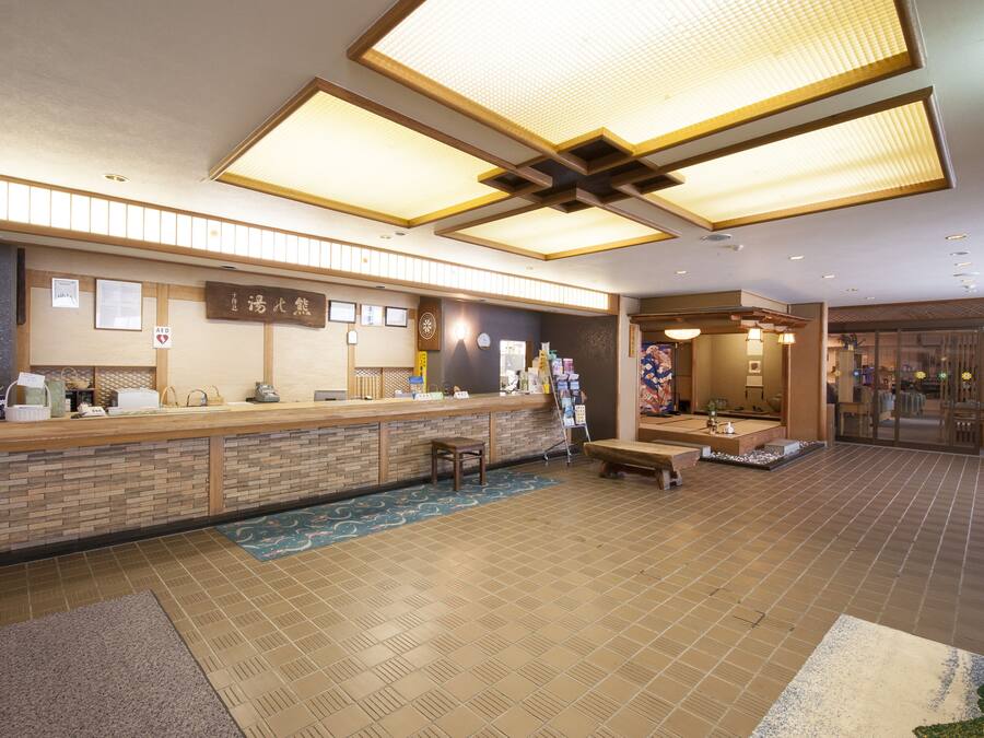 A reception area with a wooden counter, seating, and a decorative wall.