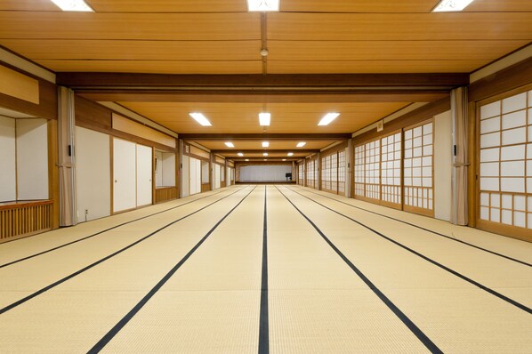 A traditional Japanese room with tatami flooring, sliding doors, and wooden beams.