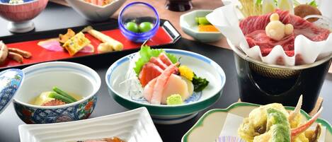 Variedad de platos que incluyen sashimi, tempura y un bol de arroz.
