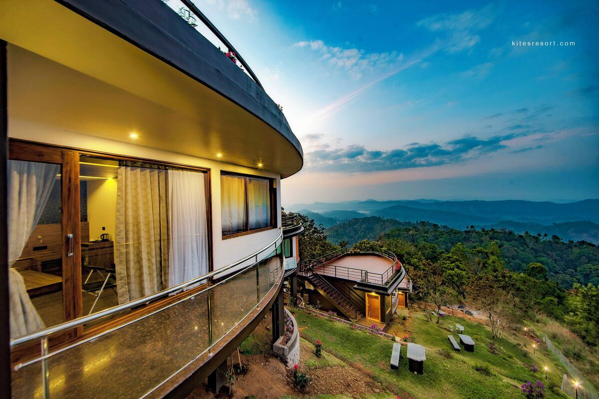 A modern hotel with a curved balcony overlooking a lush landscape.
