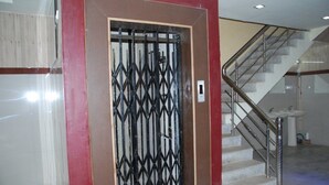 Una escalera con barandillas metálicas y una pared roja.