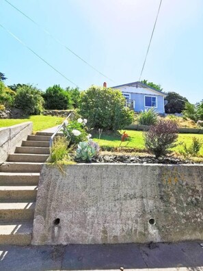 A residential property with a concrete retaining wall, a set of stairs, and a house in the background. - 180 Degrees sea view house (Oamaru)