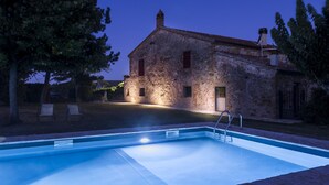 A swimming pool with a stone building in the background. - Beautiful restored farmhouse with swimming pool in the quiet of the Sienese hills. (Trequanda)