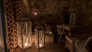 A cozy room with a brick wall, wicker furniture, and lit lanterns. - Beautiful restored farmhouse with swimming pool in the quiet of the Sienese hills. (Trequanda)