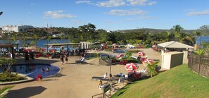 Un complexe hôtelier doté d’une piscine, de chaises longues et offrant une vue sur l’eau.