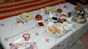 A table set with various food items and a teapot, suggesting a meal or snack setup. - Riad Bab Berdaine (Meknes)
