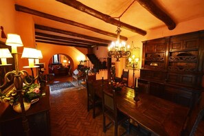 Un espace de restauration à l’éclairage chaleureux, doté de meubles en bois, d’un lustre et d’un parquet à motifs en chevrons.