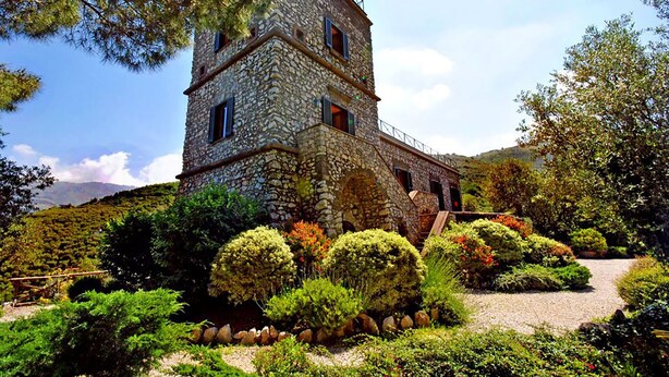 A stone tower with a staircase leading up to a balcony, surrounded by well-maintained gardens and a clear sky. - Relais La Torricella - Villa in the Sorrento Peninsula (Vico Equense)