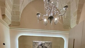 A bedroom with a large bed, a chandelier, and a painting on the wall. - Holiday House '' Lu Barocco '' (San Pancrazio Salentino)
