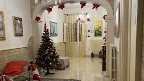 A spacious living room with a Christmas tree, a chandelier, and holiday decorations. - Holiday House '' Lu Barocco '' (San Pancrazio Salentino)