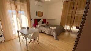 A modern bedroom with a bed, bedside tables, a desk, and a chair.