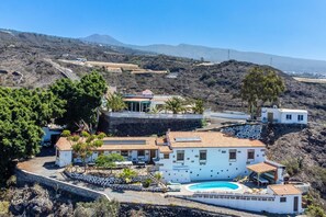 Una villa costera con piscina, varias habitaciones y vistas del paisaje circundante.