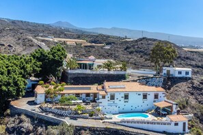 Une villa située sur la côte, dotée d’une piscine, de nombreuses pièces et offrant une vue sur le paysage environnant.