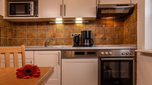 A compact kitchen with a microwave, coffee maker, oven, and dishwasher.