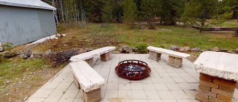 A patio area with stone benches and a fire pit.