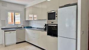 A modern kitchen with white cabinets, a built-in oven, a microwave, and a dishwasher. - Bellavista - Villa with panoramic sea views and large terraces (Calpe / Calp)