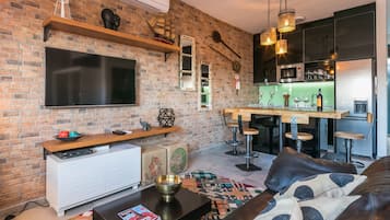 Apartamento familiar, 1 habitación, vistas a la ciudad | Sala de estar | Televisión de pantalla plana de 42 pulgadas con canales por cable