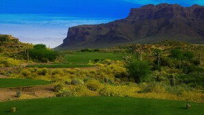 Ein Golfplatz vor einer Bergkulisse.