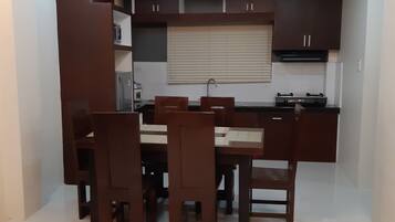 Una cocina compacta con armarios de madera oscura, una isla central con asientos y una estufa integrada.