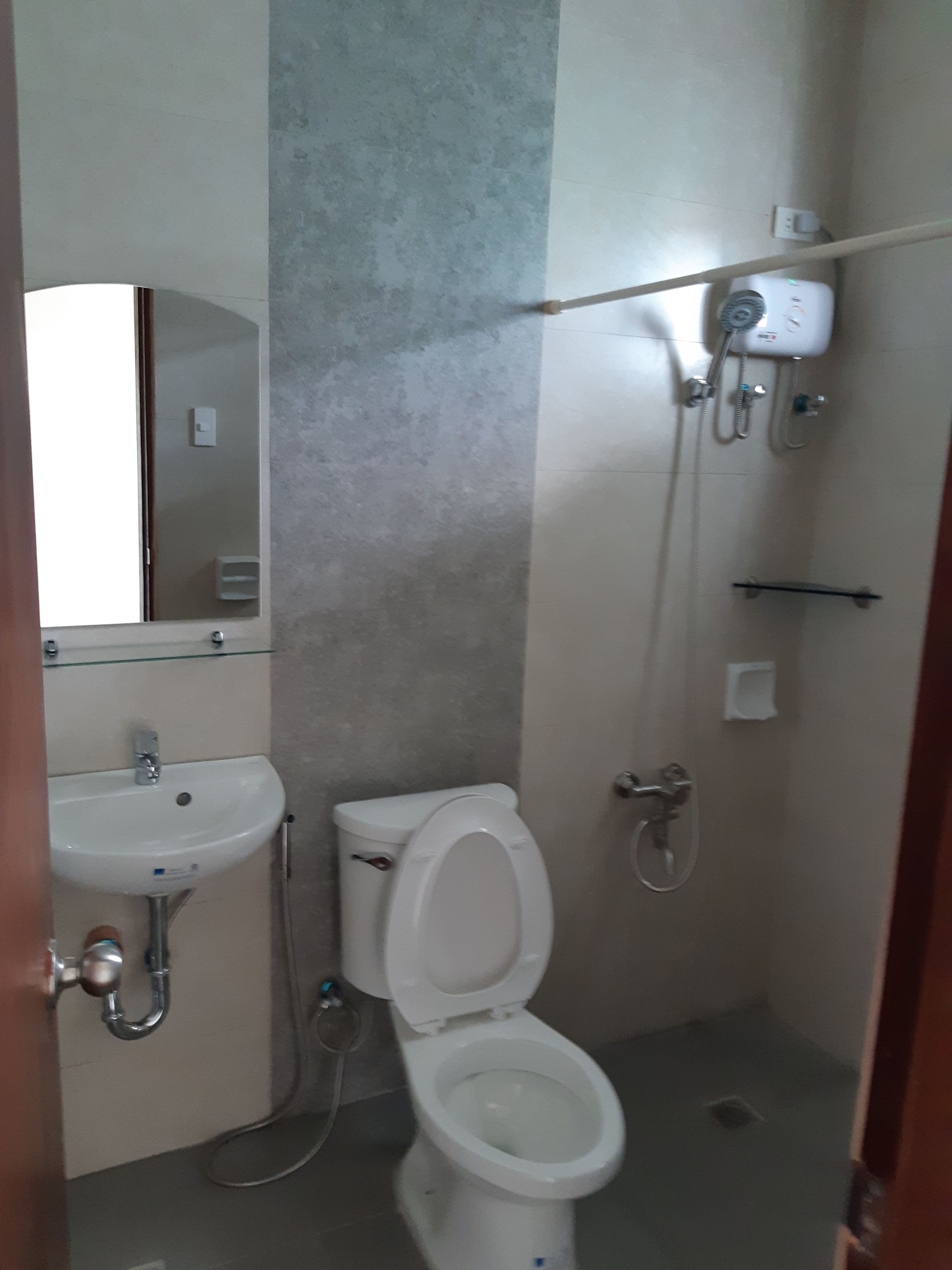 Un baño con inodoro, lavamanos y ducha.