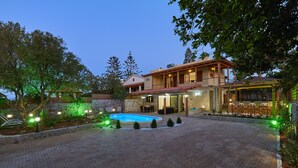 A two-story house with a swimming pool, outdoor seating, and a well-maintained garden. - Feronia Villas (Hersonissos)