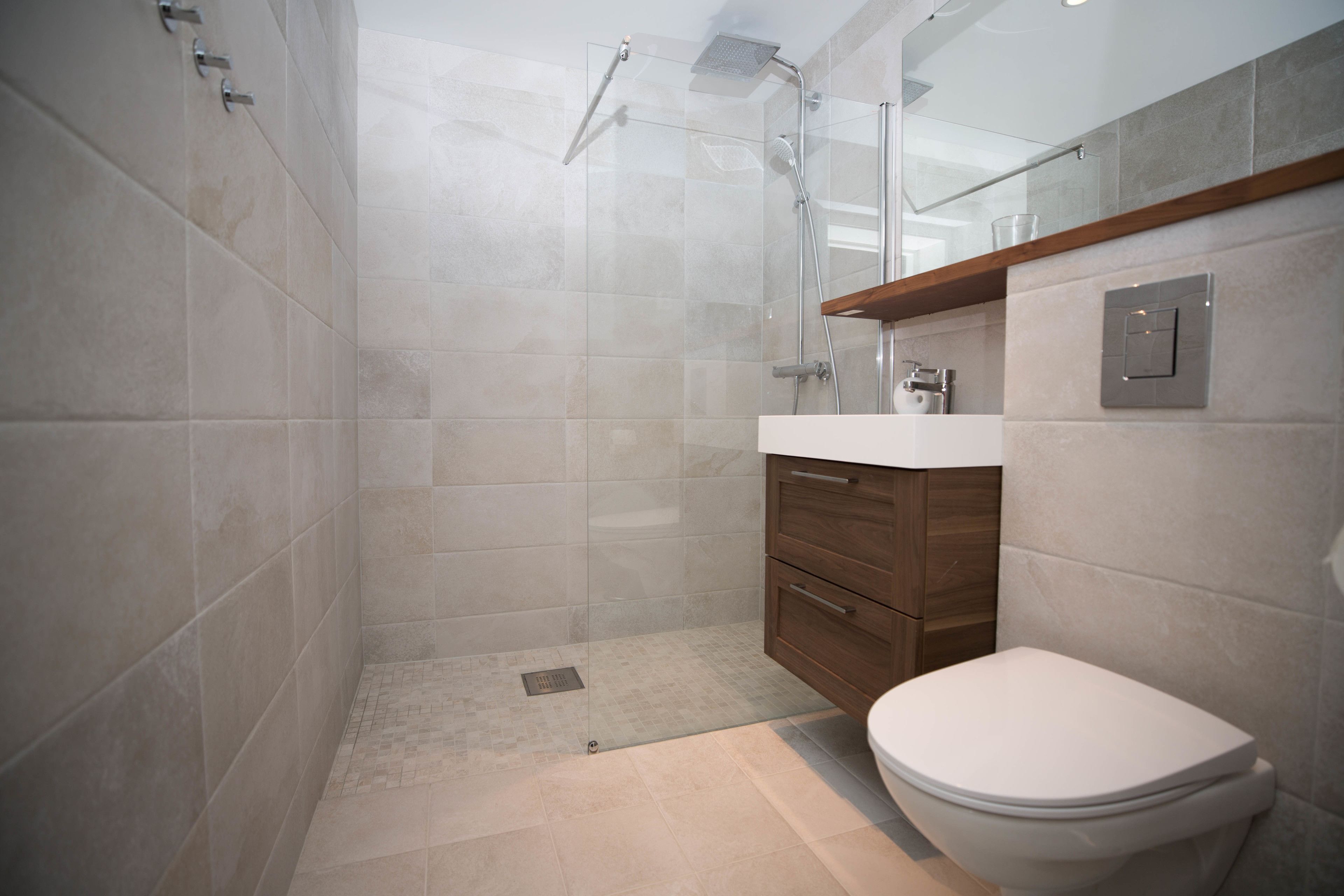 A modern bathroom with a shower, toilet, and vanity.