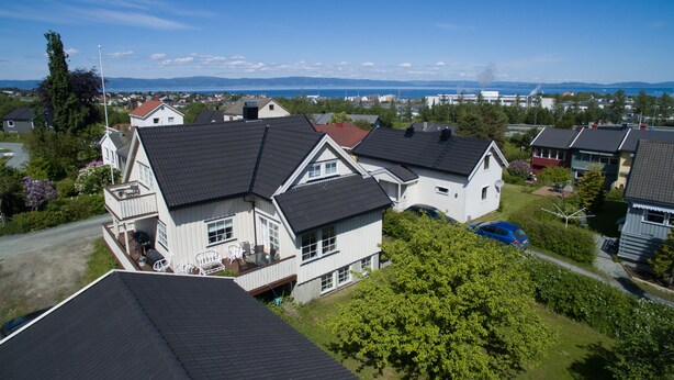 A residential area with houses, a clear sky, and a distant view of mountains.