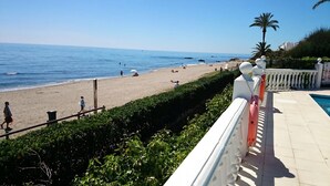 Vista de una playa con zona de piscina, incluyendo una barandilla y un cartel.