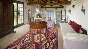 A room with a wooden ceiling, a patterned rug, a bed, a sofa, and a decorative star on the wall. - Guesthouse 2/4 people, 2 rooms, kitchen, bathroom, patio, A/C, pool, EV charger (San Casciano in Val di Pesa)
