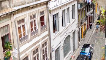 A narrow street with buildings featuring balconies and windows.