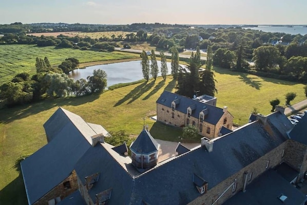 A historic building with a courtyard, a pond, and surrounding greenery. - Le Manoir de Kerbot (Sarzeau)